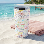 Character Autographs tumbler beside a blush towel overlooking a tropical sandbar