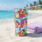 Colorblock Mickey tumbler beside a lilac towel and colorful beach huts