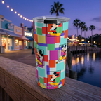 Colorblock Mickey tumbler overlooking colorful waterfront boutiques at dusk