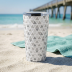 Epcot tumbler beside a teal towel and tropical timber pier