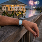 Festive watchband beside a glowing waterfront pavilion