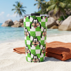 Goofy tumbler beside an orange towel on a tropical beach