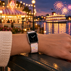 Pink autograph watchband beside a glowing waterfront pavilion