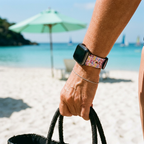 Pink bow-pattern watchband at a tropical beach