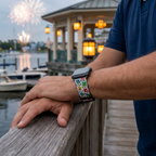 Stamp-pattern watchband beside an illuminated waterfront pavilion