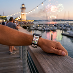 White festive watchband beside a glowing marina lighthouse